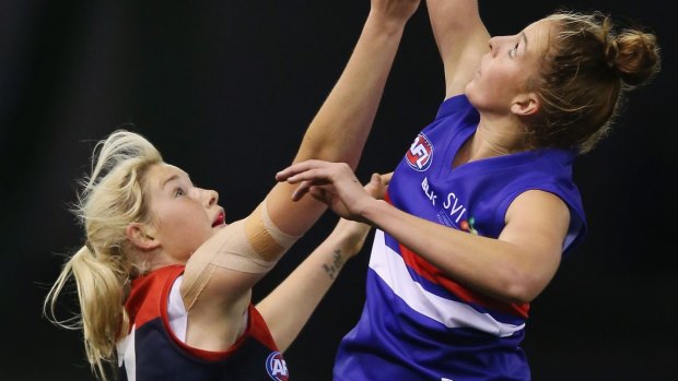 Maximum reach: The Bulldogs' Emma king wins the tap over Tayla Harris of the Demons during a Women's AFL exhibition match at Etihad Stadium on Sunday.