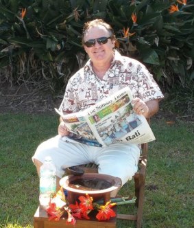 The conman seen reading the Fiji Sunday Times newspaper with what he claims is a bowl of kava.