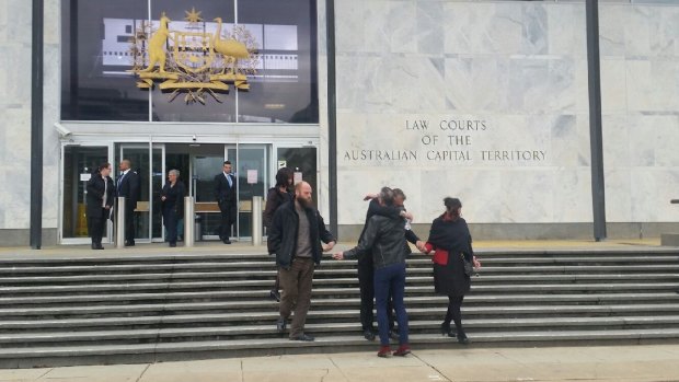 Supporters of former G&A Security owners, the Tibbitts family, embrace outside the ACT Supreme Court on Tuesday.