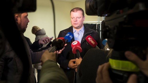 Lithuania's Peasant and Green's Union (LPGU) party leader Salius Skvernelis speaks to the media at a polling station.