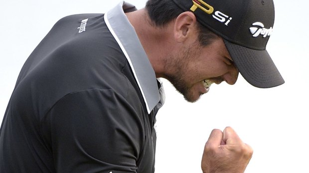 Jason Day celebrates after sinking a putt for par on the 18th.
