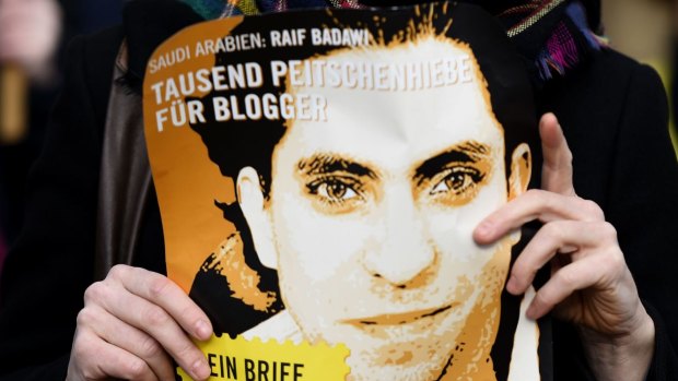 An Amnesty International activist holds a picture of Saudi blogger Raif Badawi at a protest in Germany in January. 