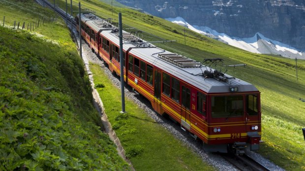 Jungfraubahn funicular train climbs to the Jungfrau from Kleine Scheidegg in the Swiss Alps in Bernese Oberland, Switzerland.