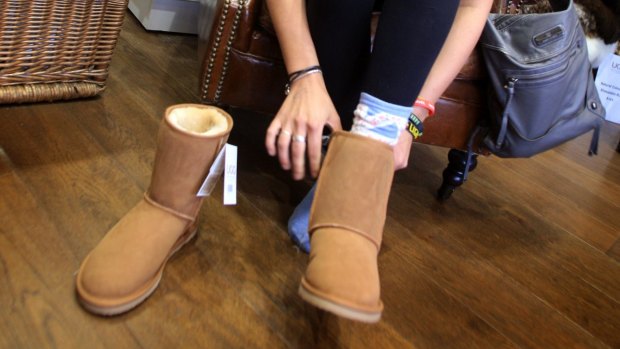 Korina Sharpe (from Britain) tries on a pair of Ugg boots at the Ugg boot store in Sydney's Rocks district.