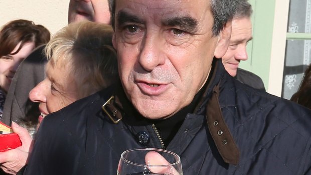 Polite: right-wing presidential candidate Francois Fillon holds a glass of local wine as he visits a farm in Chantenay-Villedieu, western France.