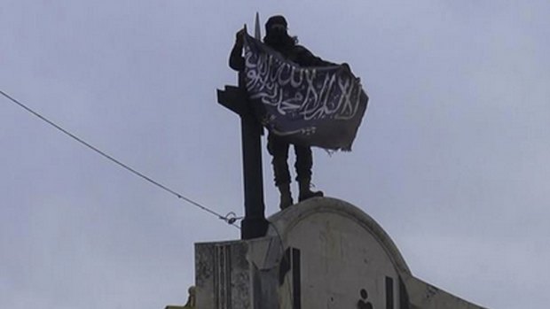 Something to fight for: a militant from Syria's al-Qaeda-linked Nusra Front holds his group flag in Idlib province, north Syria. 