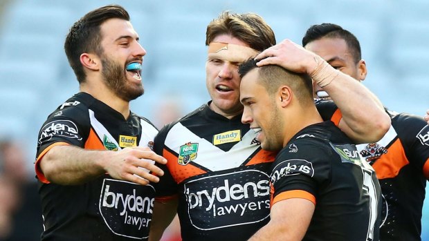 Tigers players celebrate a try by Luke Brooks.
