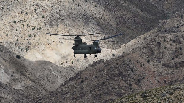 The mountainous terrain of Afghanistan dwarfs a CH-47D Chinook helicopter during a combat resupply mission in southern Afghanistan. 