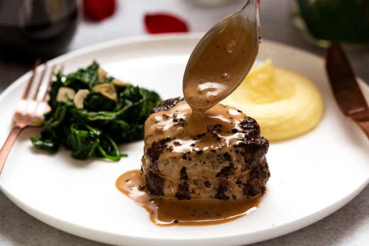 Filet mignon with creamy peppercorn sauce, garlic spinach and Paris mash.