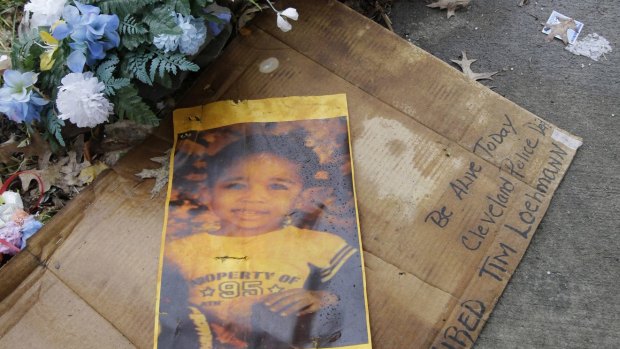 A photo of Tamir Rice rests on the ground near a memorial for him in Cleveland on Tuesday.