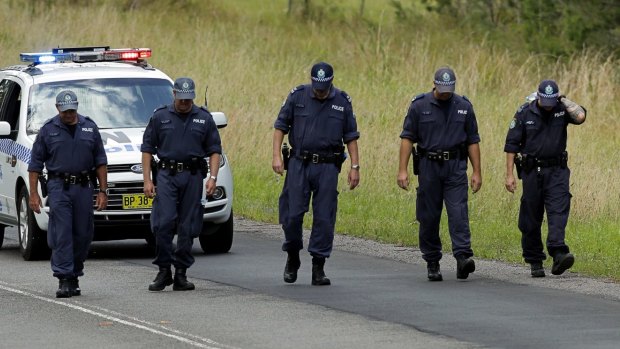 Police attend an unrelated incident on Freemans Drive near Lake Macquarie, where two vehicles collided head-on killing both drivers on Friday night. 