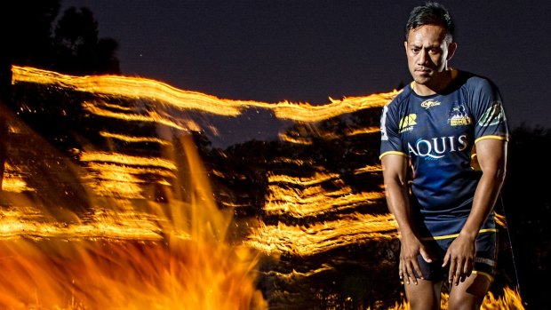 ACT Brumbies player Christian Lealiifano lines up a flaming football.