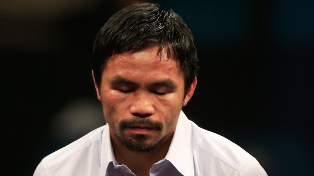 Down and out: Manny Pacquiao answers questions during the post-fight news conference.