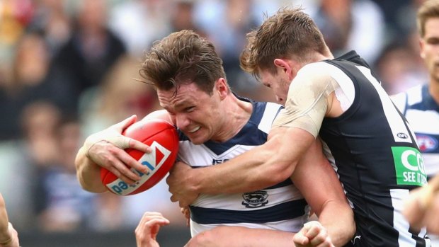 Hanging tough: Patrick Dangerfield is tackled by Magpie Taylor Adams.