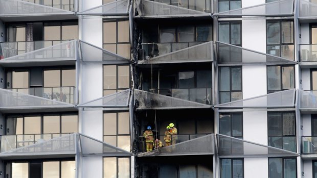 Firefighters examine the damage caused by the fire at the Lacrosse building.