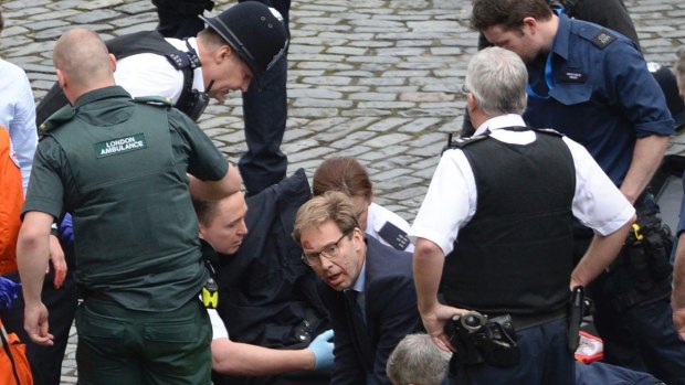 British Tory MP Tobias Ellwood, centre, helps paramedics try to revive the stabbed officer.