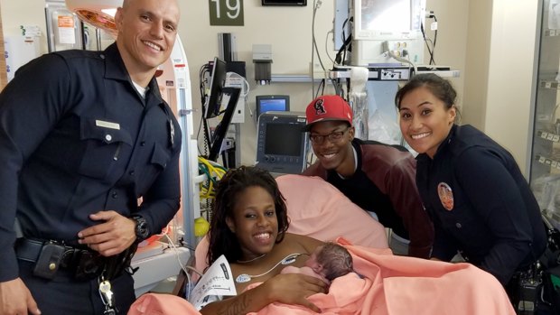 Los Angeles police officers Brian Armendariz, left, and Maraea Toomalatai with Sasha Murphy and Mohammed Tindley and their newborn son Messiah at the hospital in Los Angeles.