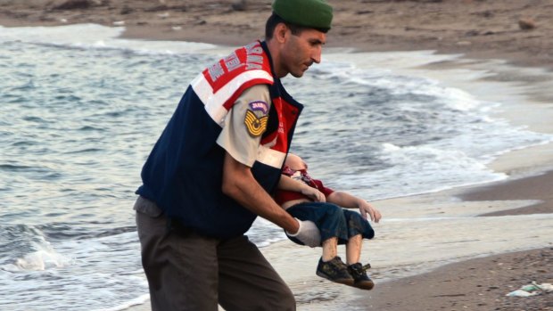 A paramilitary police officer carries the lifeless body of Aylan Kurdi, 3, after a number of migrants died and others were reported missing when boats carrying them to the Greek island of Kos capsized near the Turkish resort of Bodrum. 