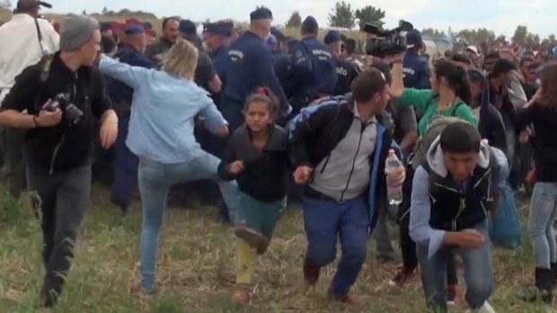 Hungarian camerawoman Petra Laszlo, centre left in blue, kicks out at a young migrant in Hungary on September 8. Laszlo has since lost her job and apologised for the incident.