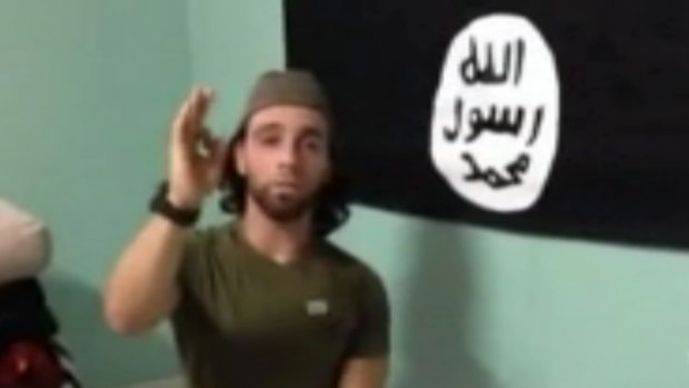 Omar Al-Kutobi in front of a homemade Islamic State flag.