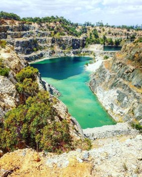 The abandoned quarry has filled with water, turning it into a popular swimming attraction. 