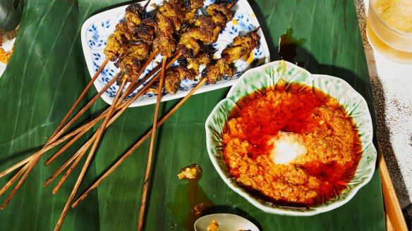 Satay sauce served alongside pork satay skewers.