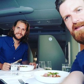 Newly engaged couple Sam Cremean, left, and Adam Seymour on a Qantas flight back to Melbourne in May after attending Eurovision in Ukraine.