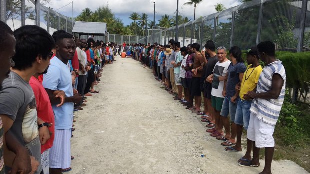 Refugees at Manus Island detention centre link hands in solidarity before the centre's closure this week.