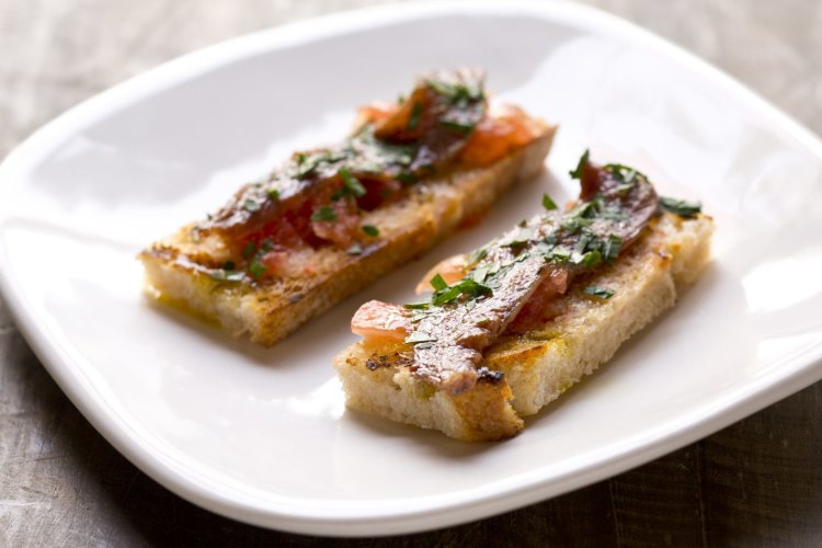 Anchovy with tomato and garlic on grilled bread 