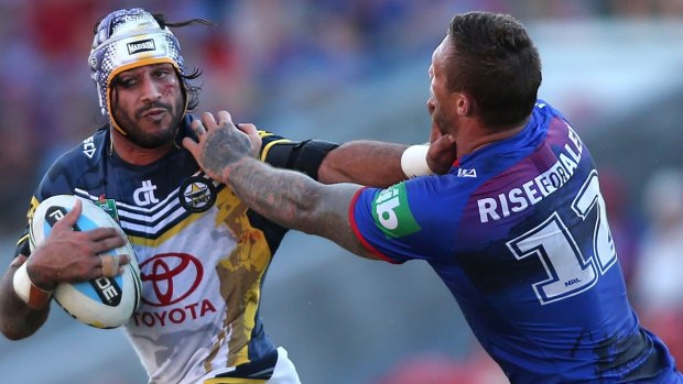 NEWCASTLE, AUSTRALIA - APRIL 25:  Johnathan Thurston of the Cowboys is tackled by Tariq Sims of the Knights  during the round eight NRL match between the Newcastle Knights and the North Queensland Cowboys at Hunter Stadium on April 25, 2015 in Newcastle, Australia.  (Photo by Tony Feder/Getty Images)