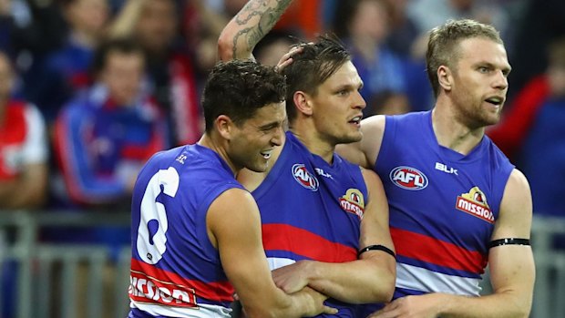 Clay Smith celebrates a preliminary final goal with his teammates.