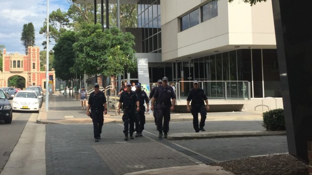 Armed police officers leave Parramatta Children's Court following the February court appearance of two teenagers charged with terrorism offences. 