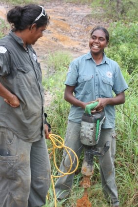 Indigenous rangers promote and maintain tourist sites, like Yupunu Marika and Grace Wunungmurra, installing tables and fences at Giddies River recreational area in NE Arnhem Land.