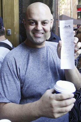 Louie Doumit holds up his receipt as the first customer to buy a coffee.