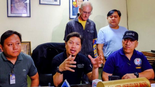 Calls for reintroduction of death penalty in the Philippines: Alleged Australian sex offender Peter Gerard Scully stands behind Philippines police investigator Angelito Magno.