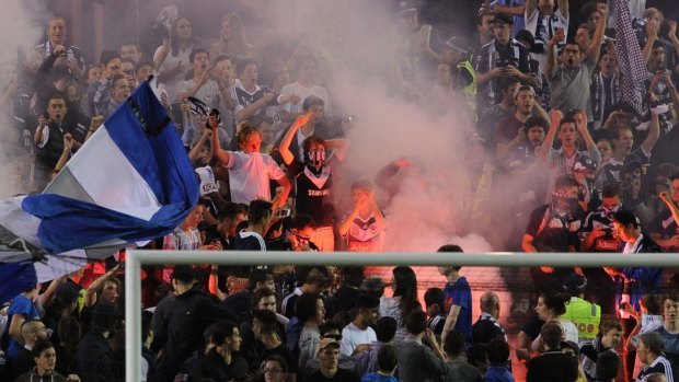 Feeling the heat: Melbourne Victory fans let off flares at Friday nights A-League match against Brisbane Roar.