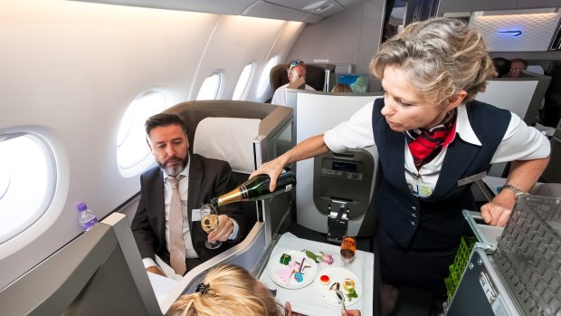 A passenger is served champagne in business class.