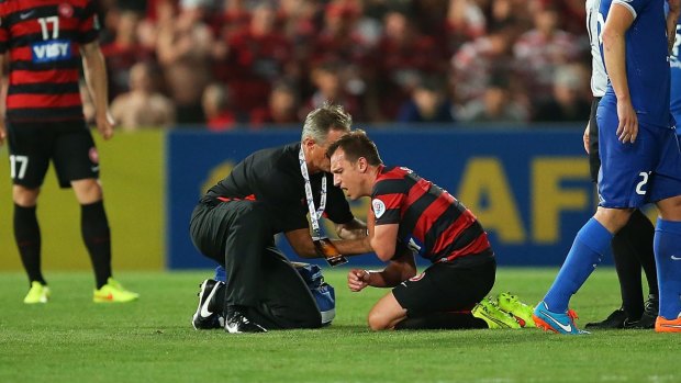 Man down: Brendon Santalab gets treatment for his injured shoulder on Saturday night.