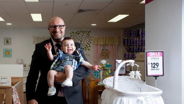 Hands full: Baby Bunting CEO Matt Spencer posing for a photo with baby Oscar James Parnall before the retailer's sharemarket listing.