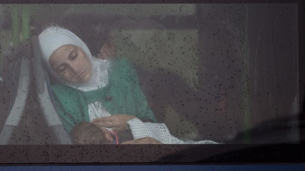 A woman sleeps on a bus that is queuing to cross the border from Hungary into Austria.