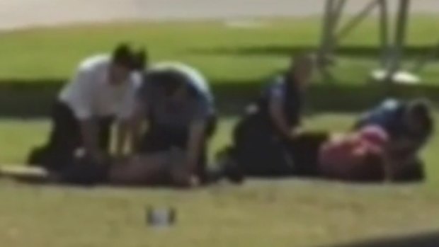 Video appears to show a police officer kneeing a man in a park.