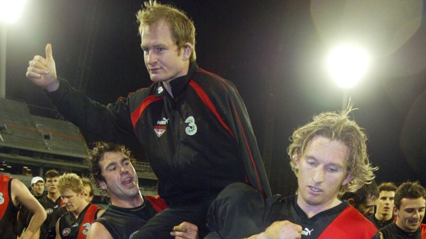 Sean Wellman is carried off the ground by teammates, including former Essendon coach James Hird. 