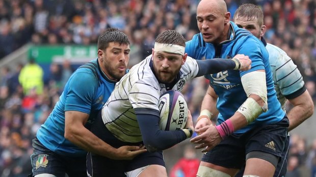 Finn Russell is caught by the Italian defence. 