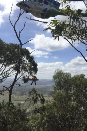 The Snowyhydro helicopter lifts the injured bushwalker, and a paramedic, from Mount Tennent, Namadgi National Park. 