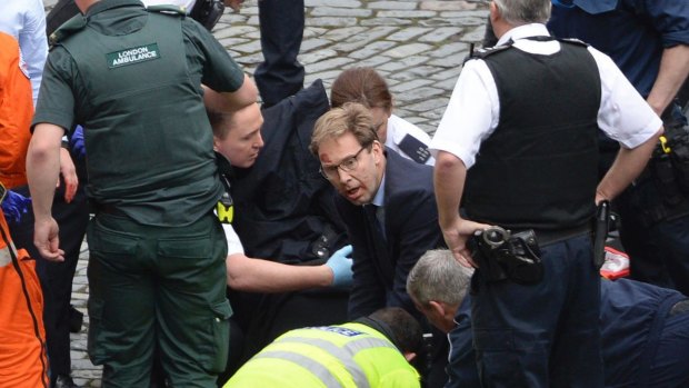 British MP Tobias Ellwood, centre, helps paramedics try to revive the stabbed officer.