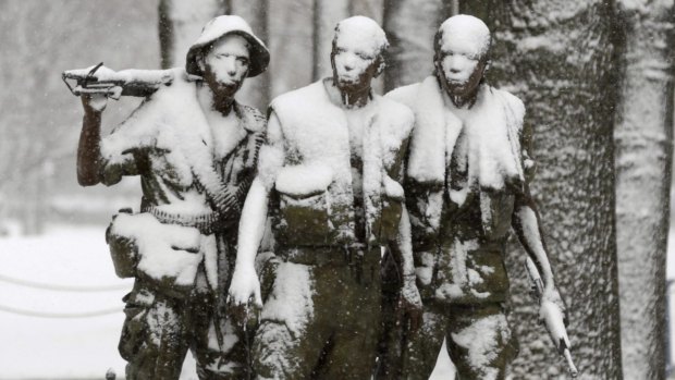 Snow-covered bronze statue "The Three Servicemen" in Washington commemorates the Vietnam War.
