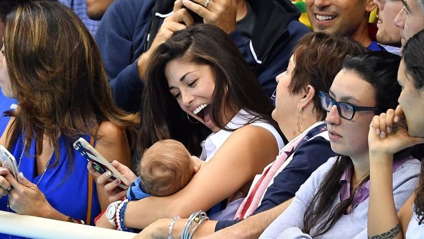 Nicole Johnson, Phelps' fiancee, with their baby Boomer in the stands.