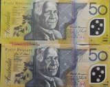 An image of a counterfeit $50 note (bottom) alongside a legitimate one.