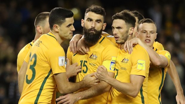 Socceroo Mile Jedinak is congratulated by teammates after his penalty. 

