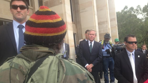 An Aboriginal elder approaches a heavily-guarded Colin Barnett.